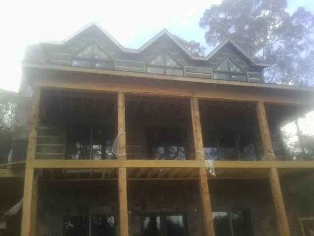 Dormers and porch framing on a large log home under construction — Roof Coating work by our crew in Absecon